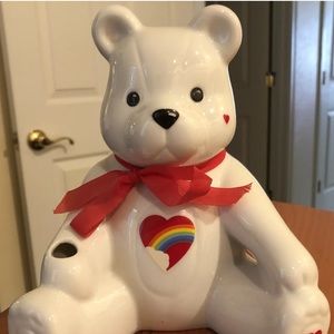 Ceramic white teddy bear bank with rainbow heart belly.